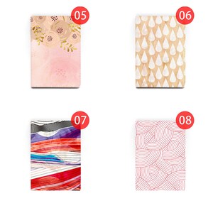 Peut inclure: Quatre designs diff&eacute;rents pour une couverture de carnet. Le premier design pr&eacute;sente un fond rose avec des motifs floraux dor&eacute;s. Le deuxi&egrave;me design pr&eacute;sente un fond beige avec des motifs de gouttes de pluie blanches. Le troisi&egrave;me design pr&eacute;sente un motif abstrait color&eacute; avec des rayures rouges, bleues et blanches. Le quatri&egrave;me design pr&eacute;sente un fond blanc avec des motifs circulaires roses.