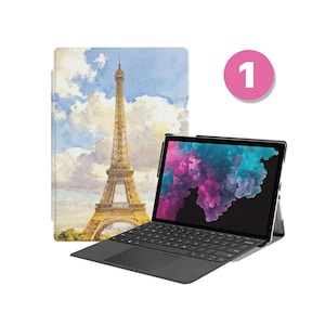 Może przedstawiać: Czarny laptop z klawiaturą i ekranem wyświetlającym kolorowy, abstrakcyjny wzór. Z tyłu etui z akwarelą Wieży Eiffla w Paryżu. Różowe koło z numerem 1 znajduje się w prawym górnym rogu.
