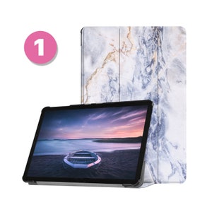 Puede incluir: Una tableta con una funda de diseño de mármol azul y blanco. La tableta muestra una imagen de un barco en una playa al atardecer.