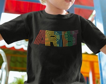 Puede incluir: Una camiseta negra con un gráfico de "ARTIST" a rayas de arcoíris.