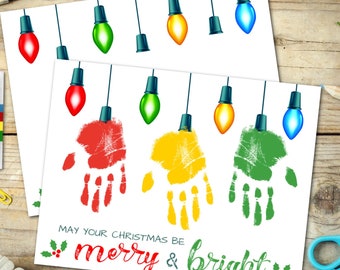 May include: A Christmas card featuring a handprint design. The card has a string of colourful lightbulbs and the text "May your Christmas be merry & bright".