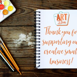 Pu&ograve; includere: Un quaderno bianco con una rilegatura a spirale su una superficie di legno. Il quaderno ha un logo che dice "my ART Box" e il testo "Grazie per aver sostenuto la nostra piccola attivit&agrave; creativa!"