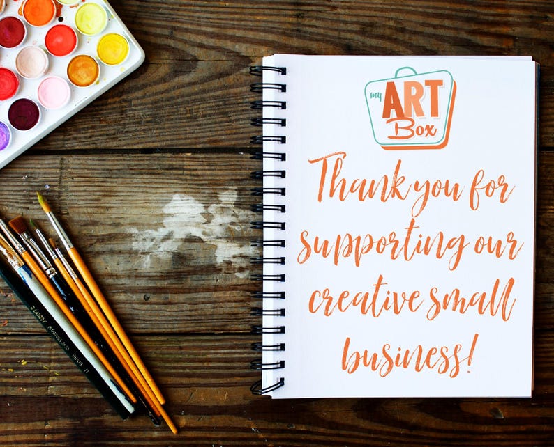 Pu&ograve; includere: Un quaderno bianco con una rilegatura a spirale su una superficie di legno. Il quaderno ha un logo che dice "my ART Box" e il testo "Grazie per aver sostenuto la nostra piccola attivit&agrave; creativa!"