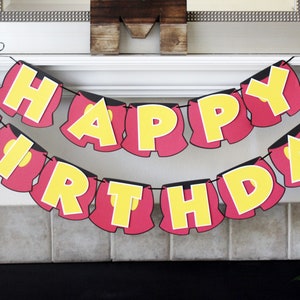 May include: A red and yellow birthday banner with the words "Happy Birthday" in a Mickey Mouse-inspired font. Each letter is shaped like Mickey Mouse's shorts.
