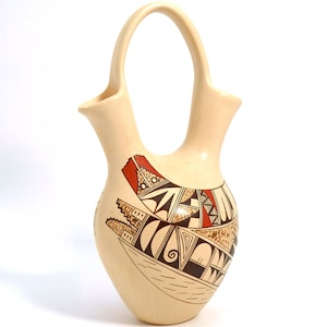 May include: A hand-painted Native American pottery vase with a double spout and a handle. The vase is decorated with geometric patterns in brown, red, and black on a cream background.