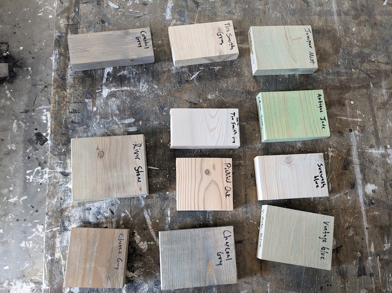 Puede incluir: Muestras de color de tinte para madera en varios tonos de verde, gris y marr&oacute;n. Las muestras est&aacute;n etiquetadas con nombres como "Juniper Mist", "Antique Jade", "River Stone", "Classic Gray", "Charcoal Gray", "Tin Smith Gray", "Pickled Oak", "Vintage Blue" y "Suawash Blue".