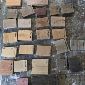 Puede incluir: Una colecci&oacute;n de 20 muestras de tinte para madera, cada una etiquetada con un nombre de color diferente. Las muestras est&aacute;n dispuestas en filas sobre una superficie marr&oacute;n claro. Los colores de tinte incluyen: Nogal oscuro, Nogal americano, &Oacute;nix de arena h&uacute;meda, &Oacute;nix, Caf&eacute;, Negro cl&aacute;sico, Chocolate holand&eacute;s, Nogal especial, Caf&eacute;, Pino colonial, &Oacute;xido, Negro carb&oacute;n, Roble imperio, Rojo antiguo, Roble envejecido, Jacobsen, Naomi, Chocolate holand&eacute;s.