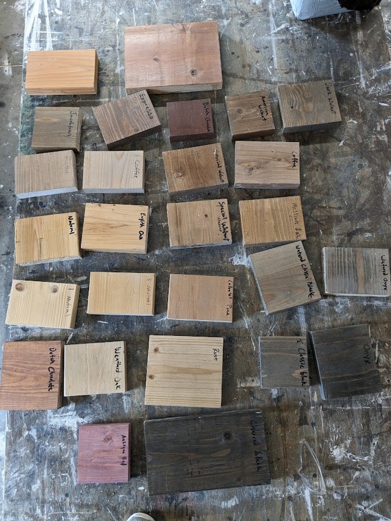 Puede incluir: Una colecci&oacute;n de 20 muestras de tinte para madera, cada una etiquetada con un nombre de color diferente. Las muestras est&aacute;n dispuestas en filas sobre una superficie marr&oacute;n claro. Los colores de tinte incluyen: Nogal oscuro, Nogal americano, &Oacute;nix de arena h&uacute;meda, &Oacute;nix, Caf&eacute;, Negro cl&aacute;sico, Chocolate holand&eacute;s, Nogal especial, Caf&eacute;, Pino colonial, &Oacute;xido, Negro carb&oacute;n, Roble imperio, Rojo antiguo, Roble envejecido, Jacobsen, Naomi, Chocolate holand&eacute;s.