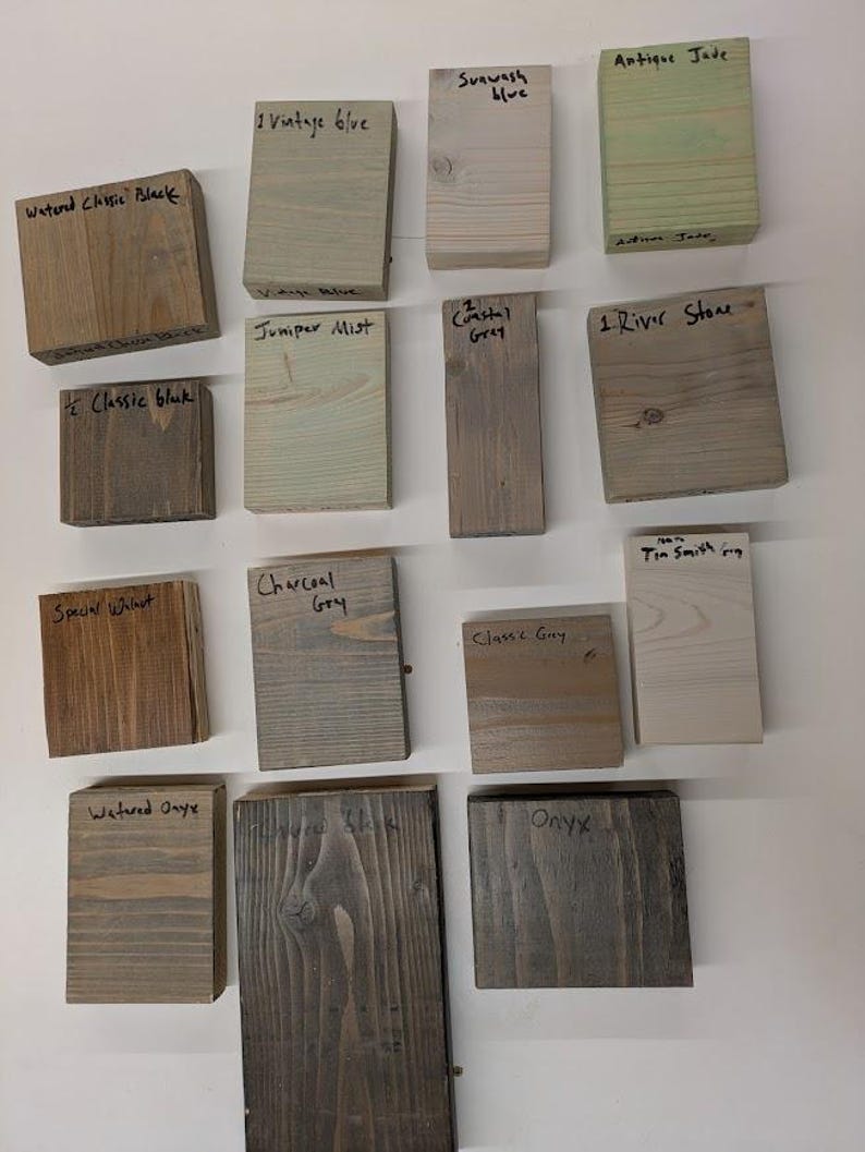 May include: A collection of 14 wood stain samples, each with a different color and name. The names include Vintage Olive, Sunwash Blue, Antique Jade, Watered Classic Black, Juniper Mist, Coastal Grey, River Stone, Classic Black, Special Walnut, Charcoal Grey, Classic Grey, Tin Smith Grey, Watered Onyx, and Onyx.