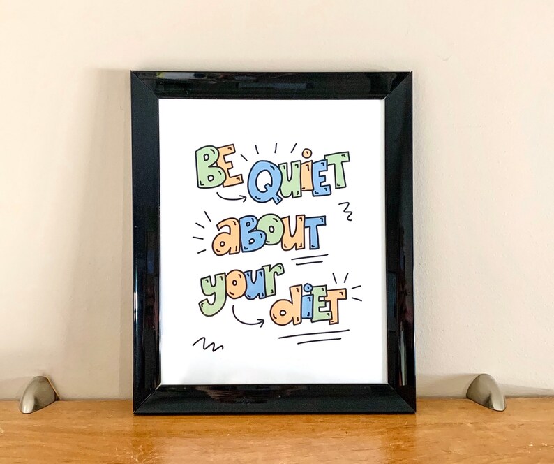 Puede incluir: Una impresi&oacute;n enmarcada en negro con el texto "Be Quiet About Your Diet" en letras coloridas y juguetonas. El texto est&aacute; escrito en una fuente caprichosa con flechas y garabatos.