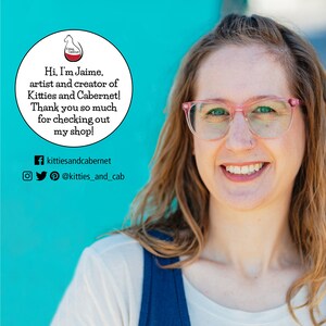 May include: A woman with pink glasses and a nose ring smiles at the camera. She is wearing a blue and white shirt. The background is a bright turquoise blue. A white circle with text reads "Hi, I'm Jaime, artist and creator of Kitties and Cabernet! Thank you so much for checking out my shop!" with social media links below.
