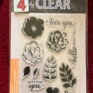 May include: A set of 4x6 inch clear stamps with floral and leaf designs. The stamps include the phrases "love you", "hello beautiful", and "just for you".