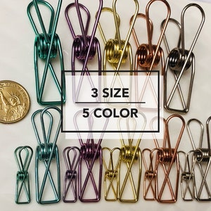 May include: A variety of colorful metal binder clips in three sizes. The clips are arranged in rows and are available in five colors: green, purple, gold, copper, and silver. The text "3 SIZE 5 COLOR" is printed on a white background.