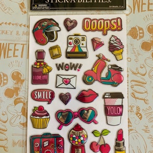May include: A sheet of 21 metallic stickers with a variety of designs, including a motorcycle helmet, a camera, a scooter, a cupcake, sunglasses, a gumball machine, a cherry, and lipstick. The stickers are all in bright colors and have a shiny finish. The sheet is labeled "Stick-A-Bilities Girl Metallic".