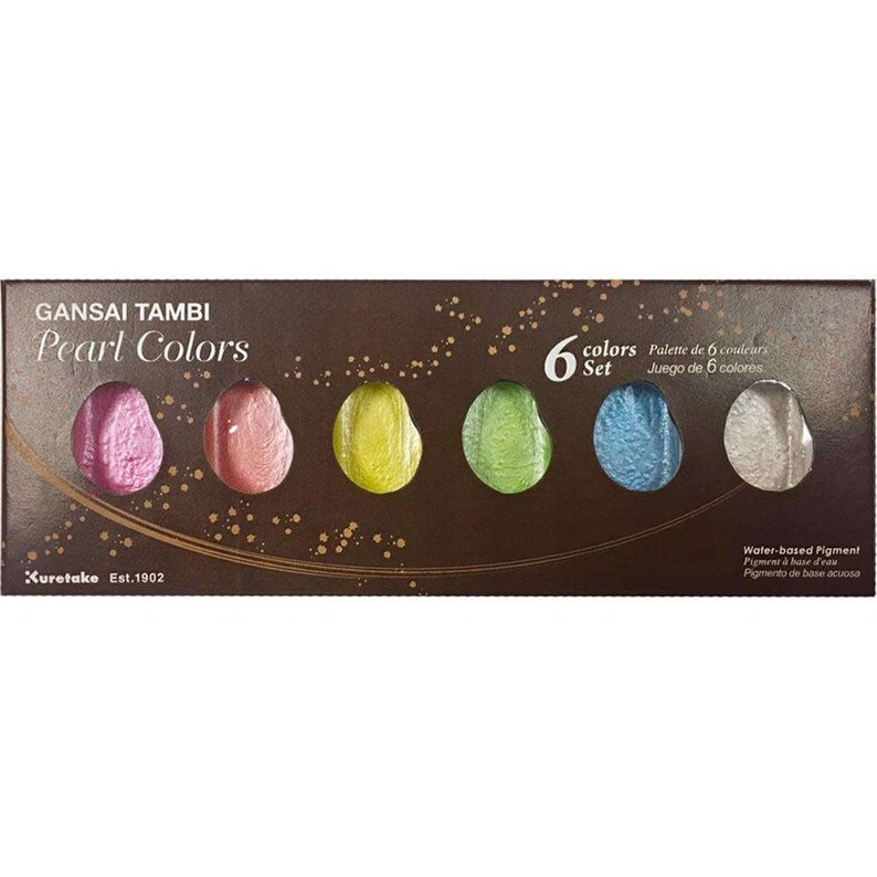 Puede incluir: Un juego de seis acuarelas nacaradas en una caja marr&oacute;n con detalles dorados. La caja tiene el texto "GANSAI TAMBI Pearl Colors" y "6 colores Set". Los colores de la pintura son rosa, rojo, amarillo, verde, azul y blanco.