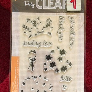 May include: A clear stamp set with the text "sending love", "thank you", "get well soon", "hello to from" and floral designs. The set is 4 inches by 6 inches.