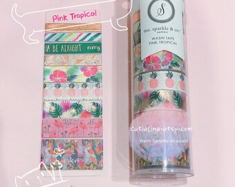 May include: A set of six pink and green tropical themed washi tapes in a clear plastic container. The tapes feature pineapples, palm leaves, flamingos, and flowers. The container has a label that says "ms. sparkle & co. PAPERIE WASHI TAPE PINK TROPICAL".