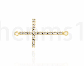 May include: Gold-toned cross charm with clear crystal embellishments. The charm has two loops for attaching to a necklace or bracelet.