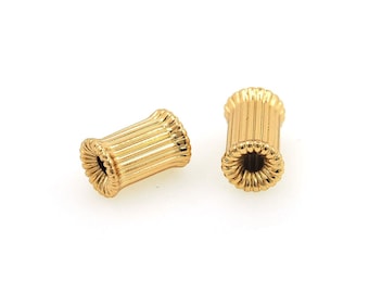 May include: Two gold-colored metal beads with a ribbed texture. The beads have a hole in the center.