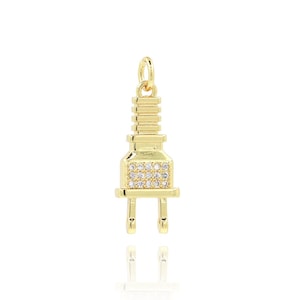 May include: Gold-tone charm in the shape of an electrical plug with clear cubic zirconia stones.