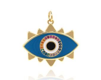 Puede incluir: Un colgante de oro con un ojo turco de esmalte azul y pupila blanca. El ojo está rodeado por un círculo de piedras preciosas de colores.