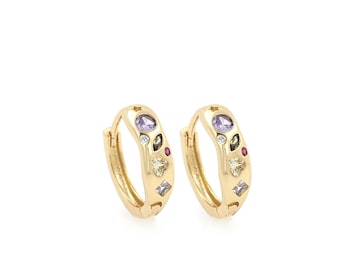 May include: A pair of gold hoop earrings with a colorful assortment of gemstones set into the band.