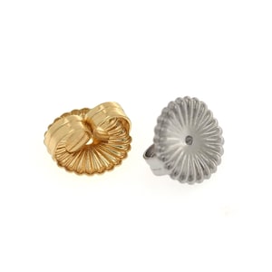 May include: A pair of gold-tone earring backs with a ridged design. The backs are shown from the front and back.