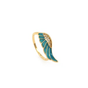Op de afbeelding: Gouden ring met een vleugelontwerp van turquoise emaille en heldere kristallen accenten.