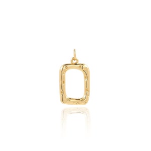 May include: A gold-toned pendant in the shape of a square with a textured surface. The pendant has a loop at the top for attaching to a chain.