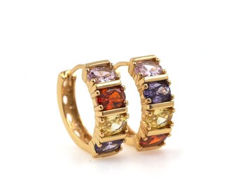 May include: Gold hoop earrings with a row of colorful gemstones. The gemstones are purple, yellow, orange, and pink.