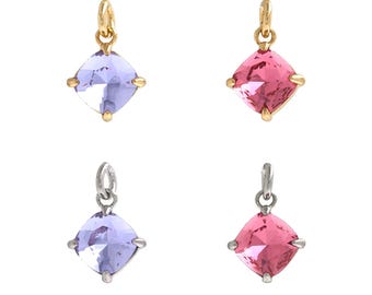 May include: Four square-shaped charms with different colored crystals. Two charms are gold-toned and feature a purple crystal. The other two charms are silver-toned and feature a pink crystal and a purple crystal.