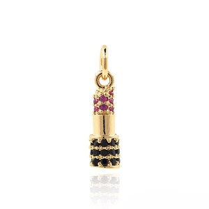 May include: Gold-tone lipstick charm with black and pink cubic zirconia stones.