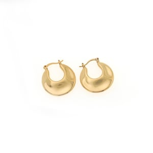 May include: A pair of gold-colored hoop earrings. The earrings have a rounded, crescent-shaped design with a smooth, polished surface. The earrings are displayed against a white background.