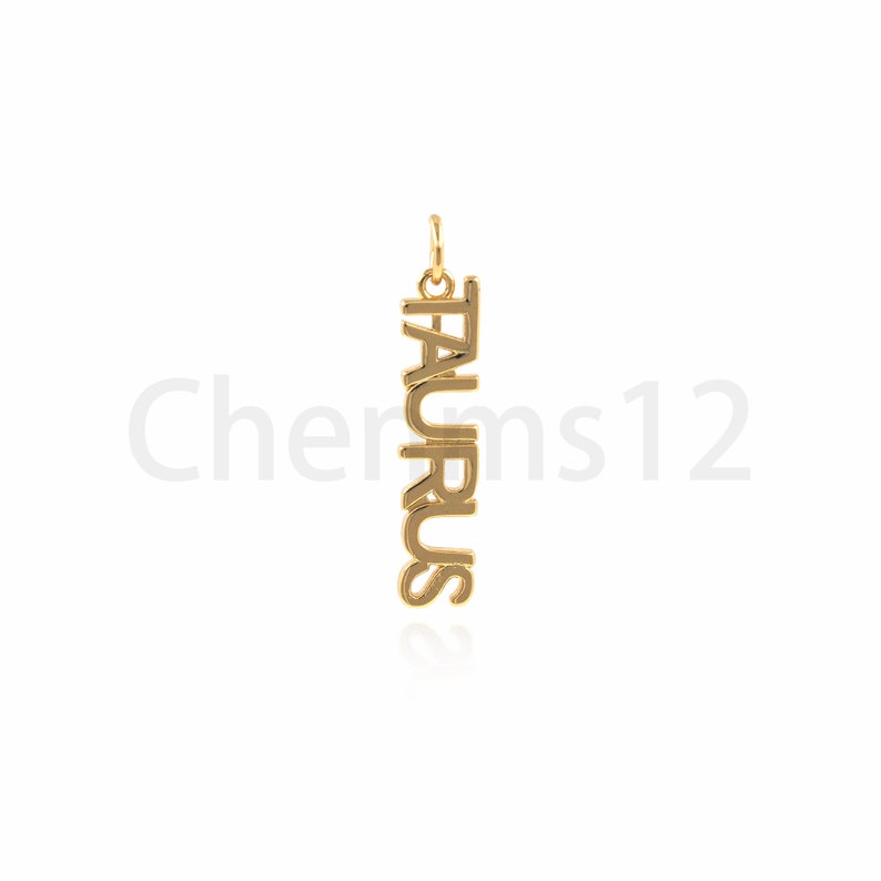 May include: Gold pendant necklace with the word "TAURUS" spelled vertically.