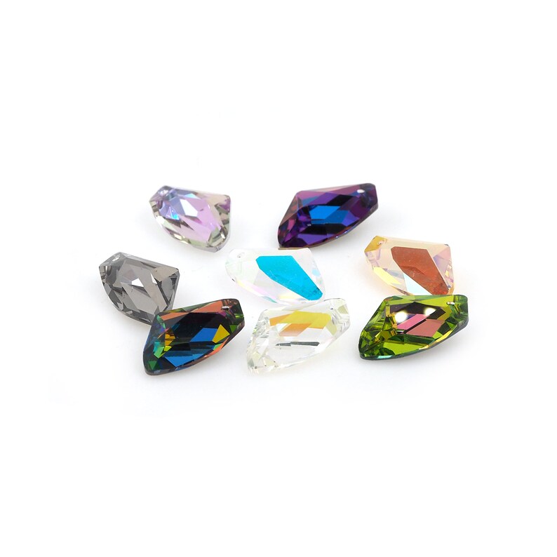 May include: Assortment of eight faceted crystal rhinestones in various colors, including purple, blue, green, and clear.