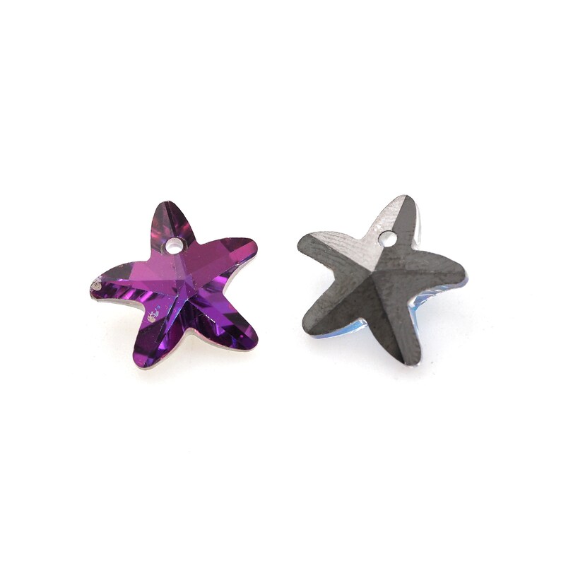 May include: Two star-shaped crystal charms, one purple and one iridescent black.