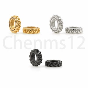 May include: Three pairs of tire-shaped rings, one pair in gold, one pair in silver, and one pair in black.