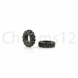 May include: Two black metal tire-shaped beads. The beads are about 1 inch in diameter and have a detailed tread pattern.