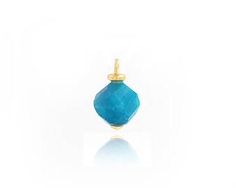 May include: A faceted, turquoise-colored gemstone pendant with gold-colored metal accents. The pendant has a geometric shape and a small loop at the top for hanging. The gold accents are at the top and bottom of the pendant.