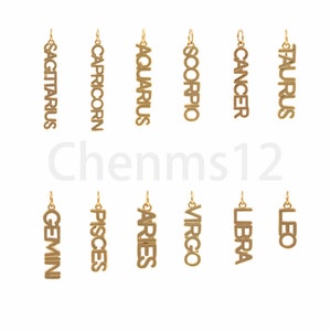 May include: Twelve gold-colored zodiac sign charms, each with a different astrological symbol. The charms are arranged in two rows of six, with the signs of Sagittarius, Capricorn, Aquarius, Scorpio, Cancer, and Taurus in the top row, and Gemini, Pisces, Aries, Virgo, Libra, and Leo in the bottom row.