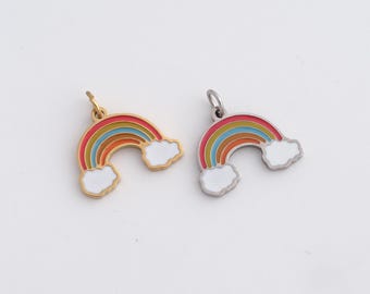 Könnte beinhalten: Zwei Regenbogen-Anhänger mit weißen Wolken. Einer hat eine goldfarbene Oberfläche, der andere eine silberfarbene. Die Regenbogen-Anhänger haben rote, orange, gelbe und blaue Bögen.