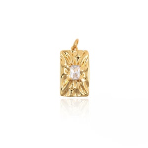 May include: Gold pendant with a textured rectangular design and a clear square-shaped gemstone in the center.