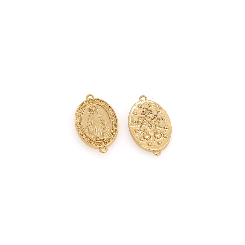 May include: Two gold-colored oval pendants. One pendant features a detailed depiction of a religious figure, while the other displays a cross, hearts, and the letter "M". Both pendants have small loops for attachment.