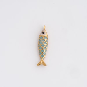 May include: A gold-colored fish pendant with a turquoise scale pattern. The fish has a small loop at the top for hanging and a white and black eye. The pendant is approximately 1.5 inches long.