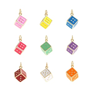 Könnte beinhalten: Neun goldene Würfel-Anhänger mit verschiedenen emaillierten Oberflächen. Die Würfel befinden sich alle in der gleichen Position, wobei die Zahl eins nach oben zeigt. Die Farben sind rosa, gelb, blau, rot, grün, lila, weiß, orange und schwarz.