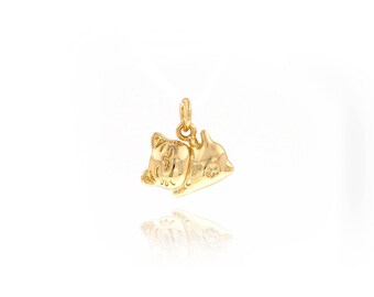 May include: A gold-colored pendant featuring a stylized cat design. The pendant has a loop for a chain and is highly reflective, suggesting a polished finish. The cat is depicted in a relaxed pose, with detailed facial features.