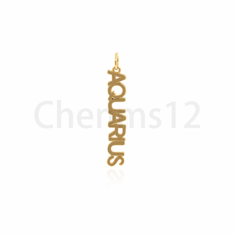 May include: Gold pendant charm with the word "Aquarius" spelled vertically.