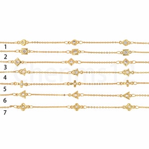 May include: Seven gold chain bracelets with different geometric charms, each with a clear crystal stone in the center. The charms include a square, diamond, star, cross, triangle, and flower.
