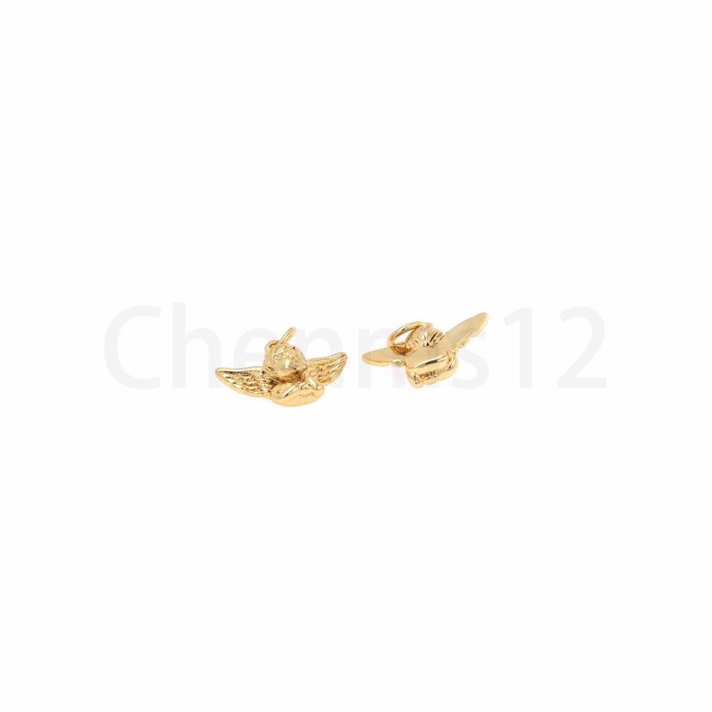 May include: Two gold-coloured angel charms with wings. The charms are small and detailed.