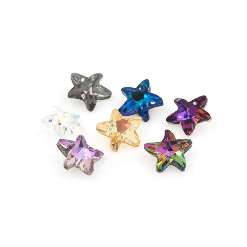 May include: Assortment of eight star-shaped crystal embellishments in various colors, including clear, black, blue, gold, and purple.
